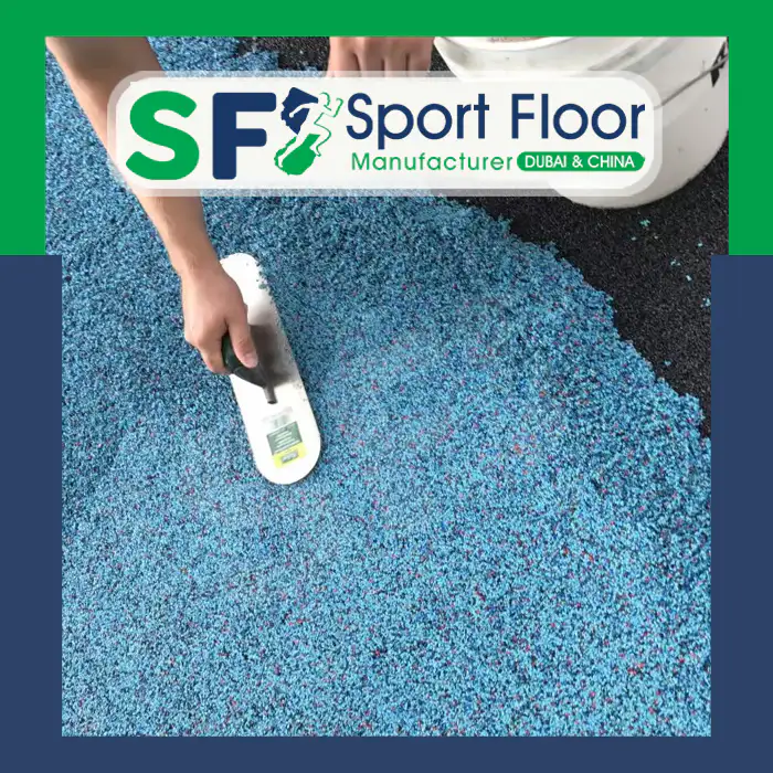 Blue mixed rubber granules being spread and levelled