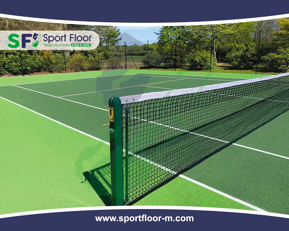 Green tennis court with net, service lines and surrounding run-off area