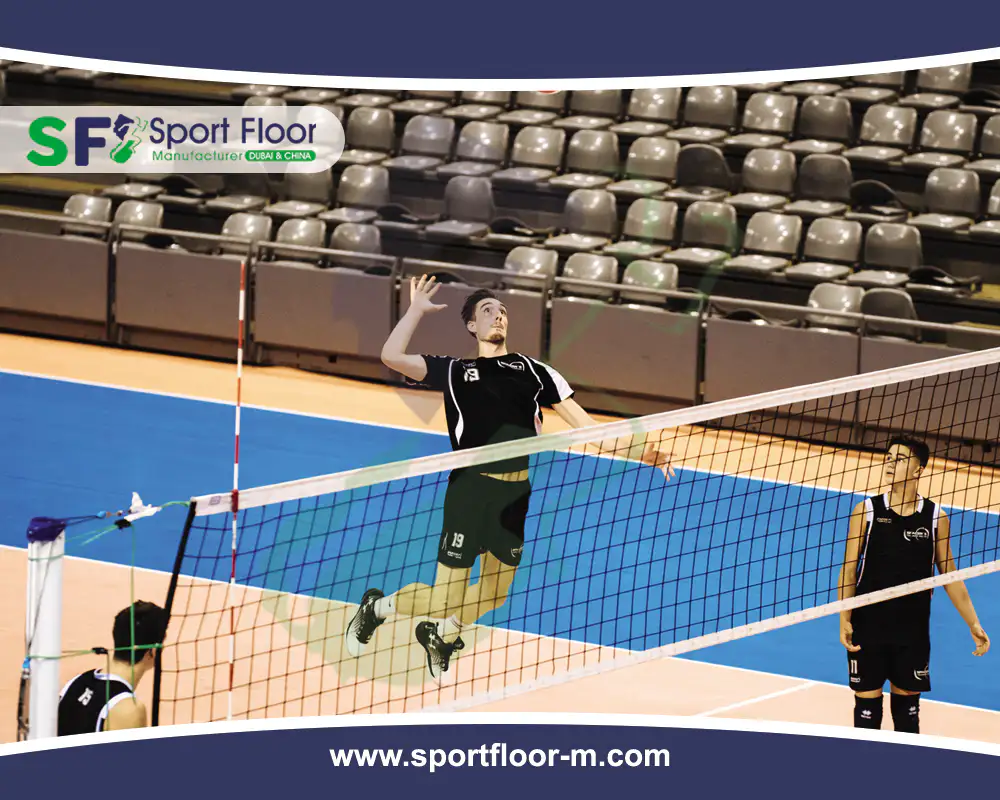 Indoor volleyball match on a blue and orange synthetic sports floor
