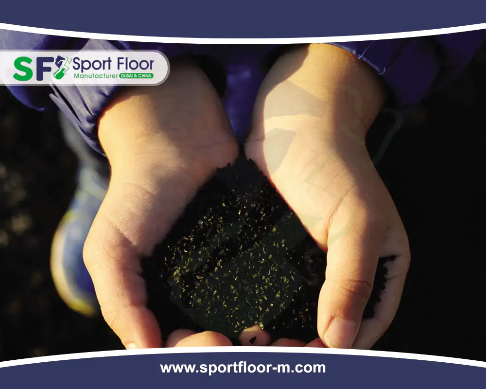 Hands holding a bowl-shaped amount of black SBR rubber granules
