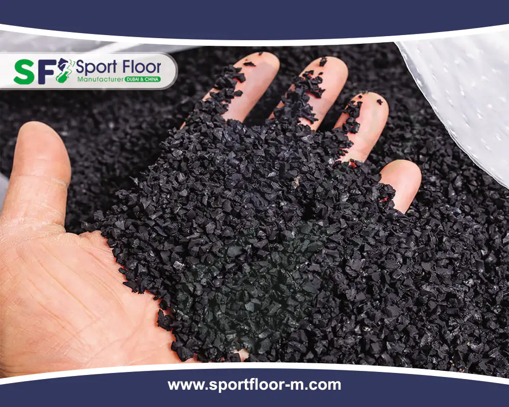 Black SBR rubber granules scooped in a hand beside a bag