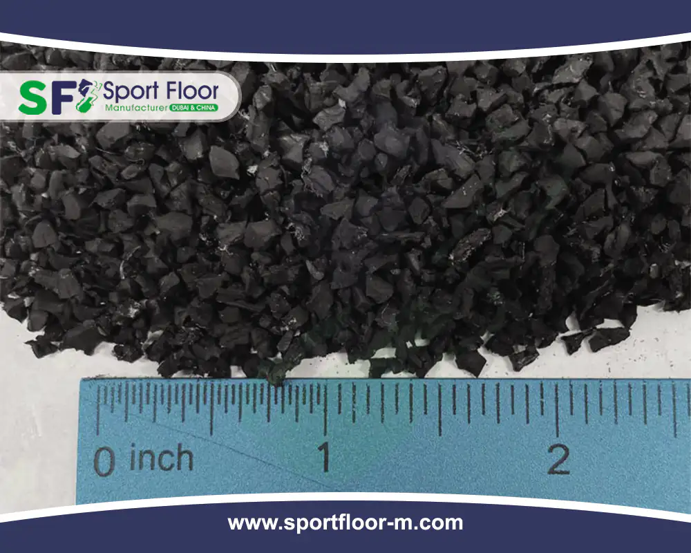 Black SBR rubber granules beside a ruler to show approximate size
